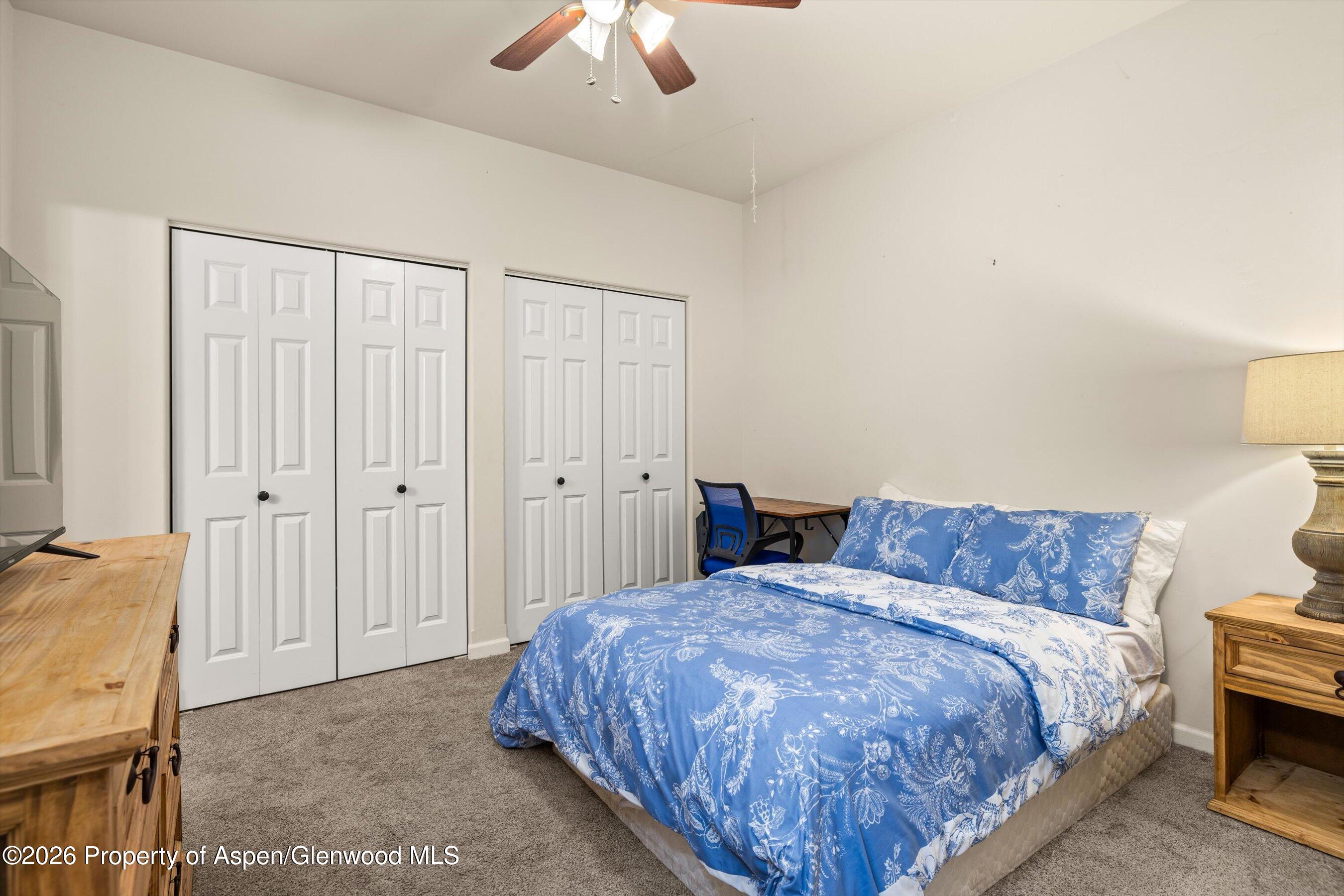 66 Castle Ridge Drive New Castle, CO 81647 - Photo 11 of 23 a spacious bedroom with a bed and a chandelier