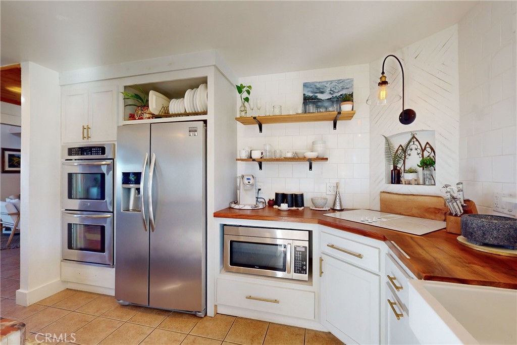 8560 Warren Road Paso Robles, CA 93446 - Photo 15 of 74 a kitchen with stainless steel appliances granite countertop a refrigerator a stove and a sink with wooden floor