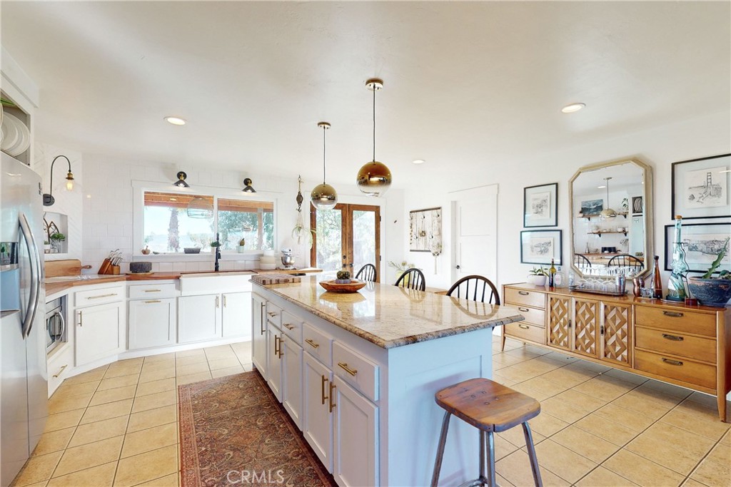 8560 Warren Road Paso Robles, CA 93446 - Photo 20 of 74 a kitchen with granite countertop a sink a stove a dining table and chairs