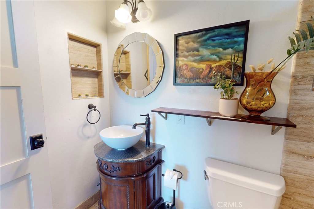 8560 Warren Road Paso Robles, CA 93446 - Photo 29 of 74 a bathroom with a toilet mirror and vanity