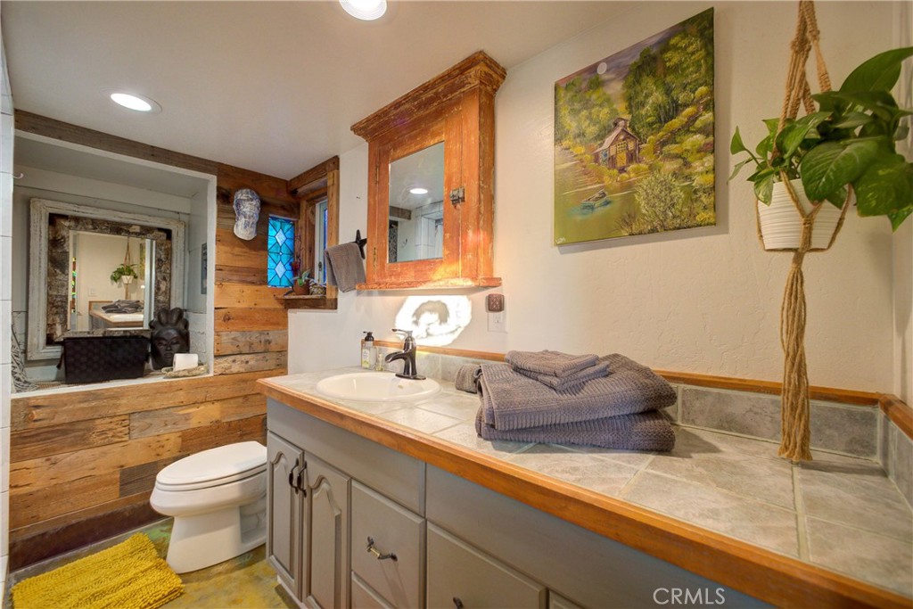 8560 Warren Road Paso Robles, CA 93446 - Photo 42 of 74 a bathroom with a granite countertop sink mirror vanity and toilet