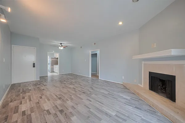 a view of empty room with wooden floor and fireplace