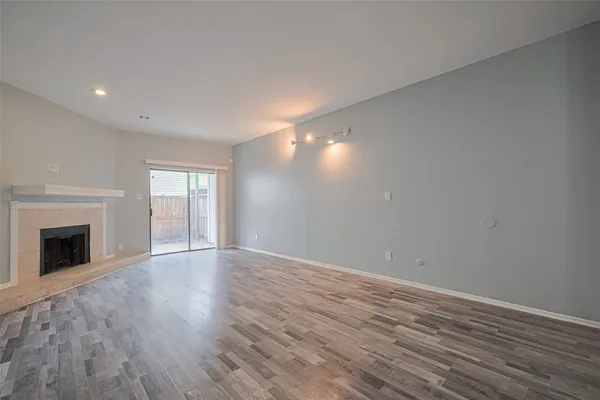 a view of empty room with wooden floor and fireplace