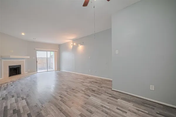 a view of empty room with wooden floor and fireplace