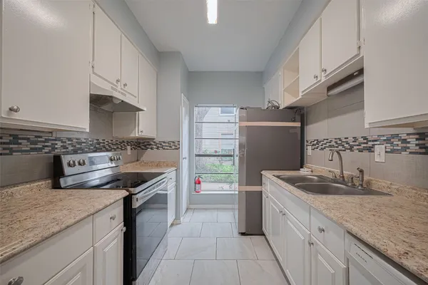 a kitchen with granite countertop a sink stove and cabinets