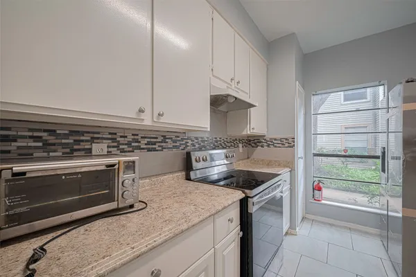 a kitchen with granite countertop a stove sink and cabinets