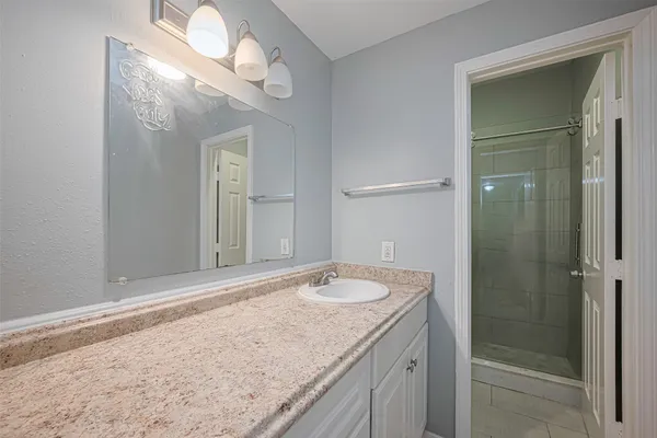 a bathroom with a granite countertop sink and a mirror