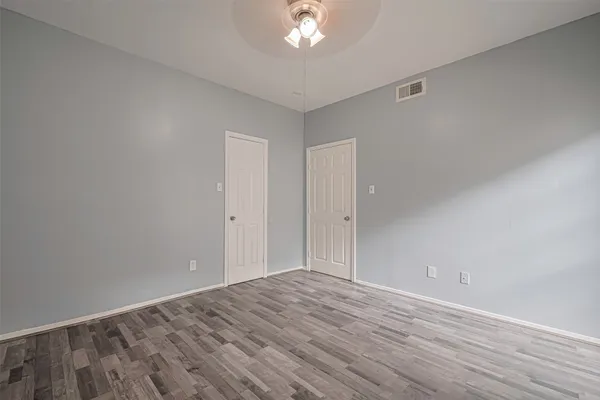 a view of a room with wooden floor and a ceiling fan