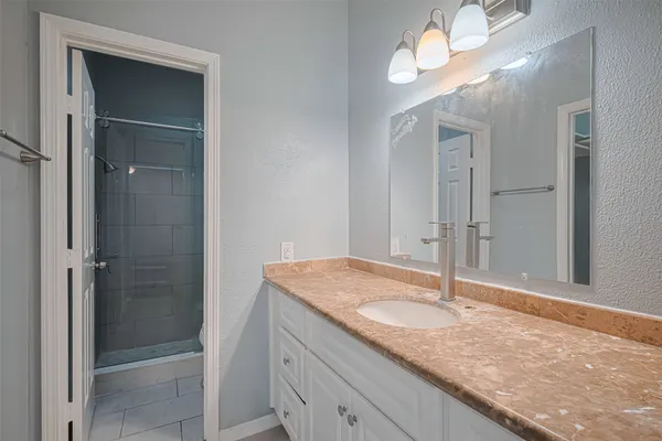 a bathroom with a granite countertop sink and a mirror