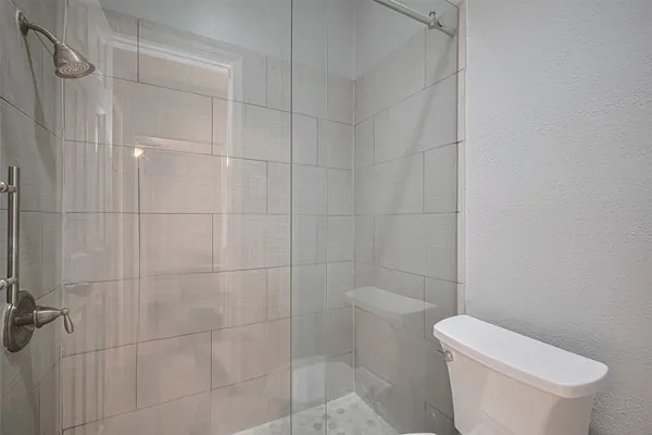 a white toilet sitting next to a bath tub