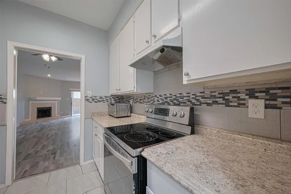 a kitchen with granite countertop a sink stainless steel appliances and cabinets