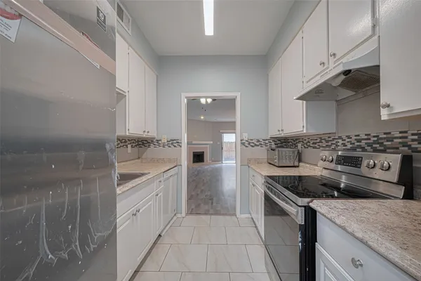 a kitchen with granite countertop a sink stove and cabinets
