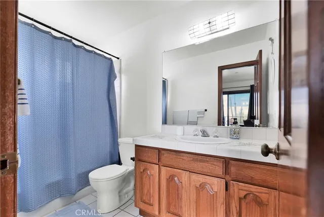 a bathroom with a double vanity sink toilet and mirror