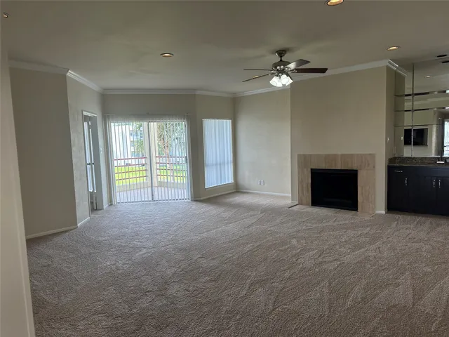 a view of livingroom with fireplace ceiling fan and windows