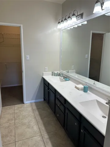 a bathroom with a double vanity sink and a mirror