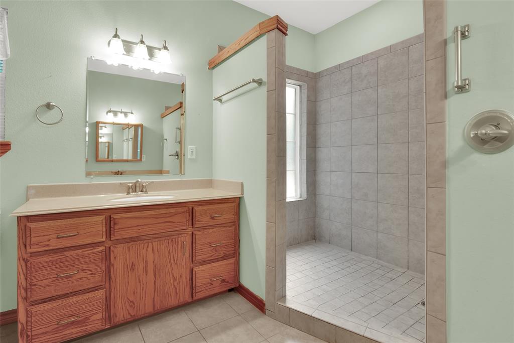 2255 Davy Lane Denison, TX 75020 - Photo 23 of 37 a bathroom with a granite countertop sink a mirror and shower