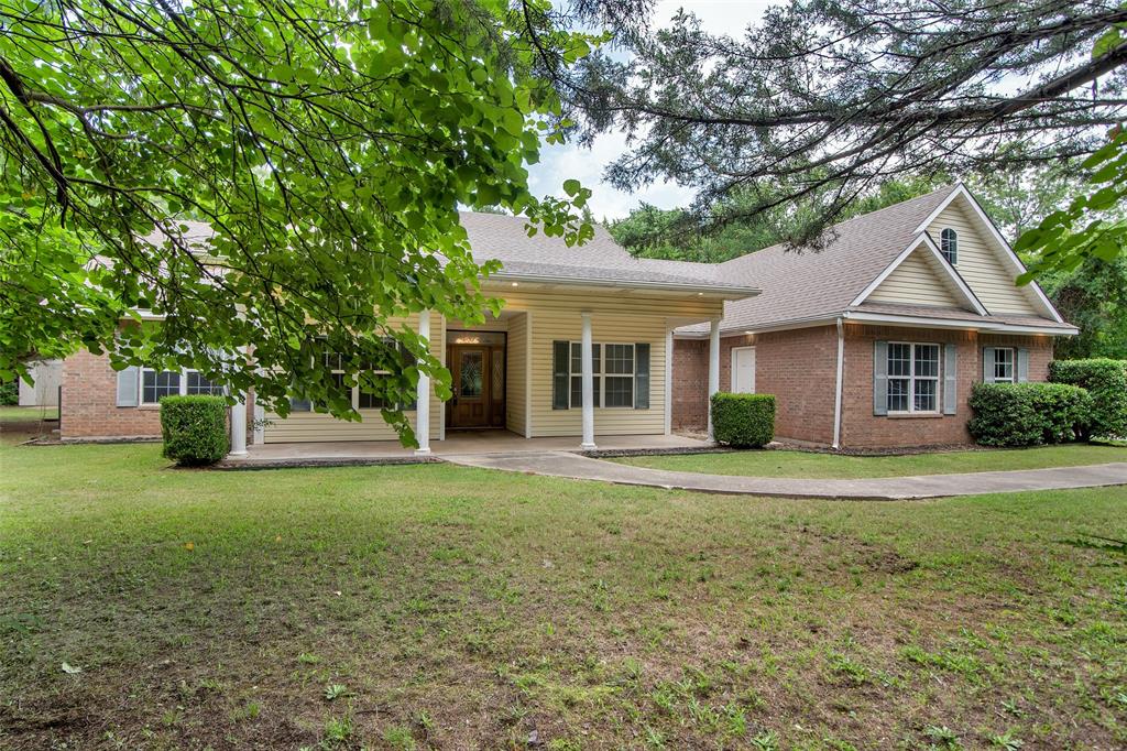 2255 Davy Lane Denison, TX 75020 - Photo 3 of 37 a front view of a house with a yard and trees