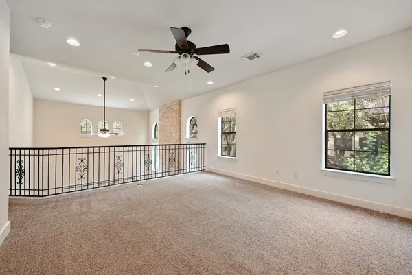 en empty room with windows and ceiling fan