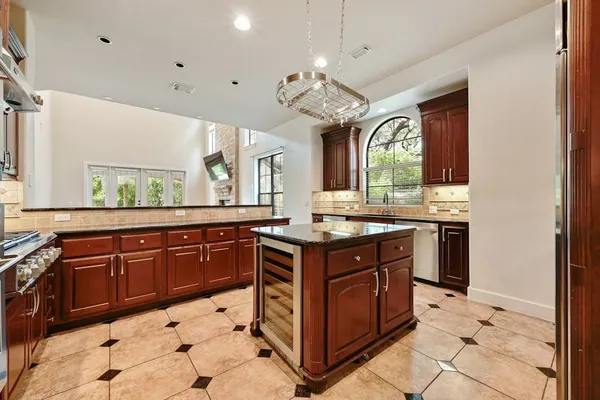 a view of a living room kitchen with a flat screen tv and a fireplace