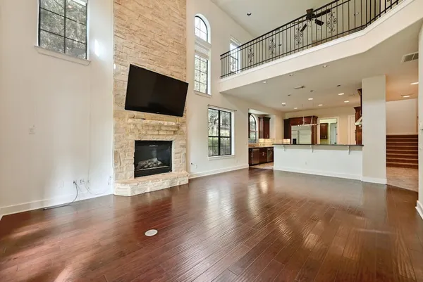 an empty room with fireplace wooden floor and windows