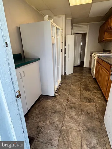 a view of a storage and utility room with refrigerator