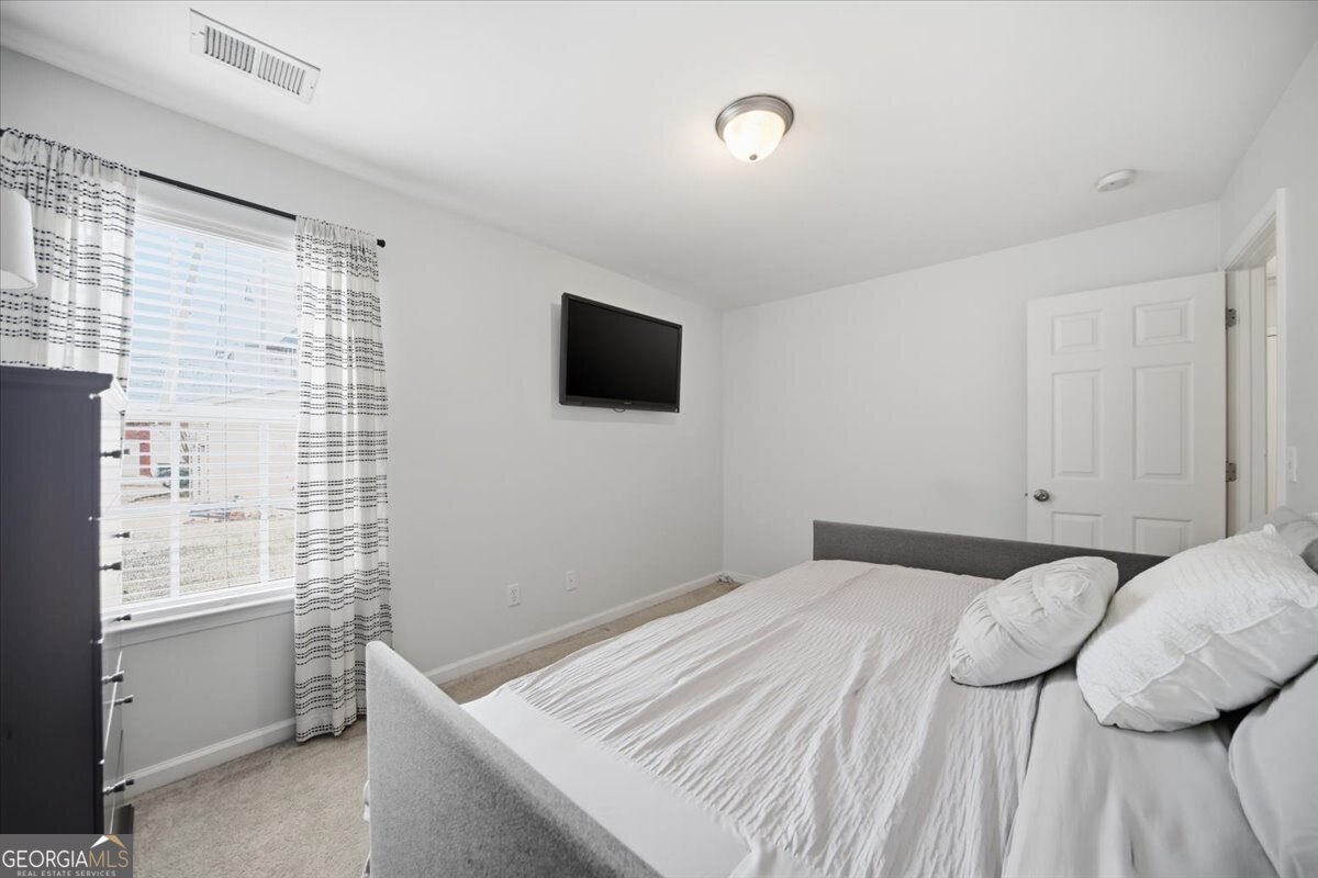 1201 Pendley Point Hampton, GA 30228 - Photo 18 of 23 a bedroom with a bed and a flat tv screen on the dresser