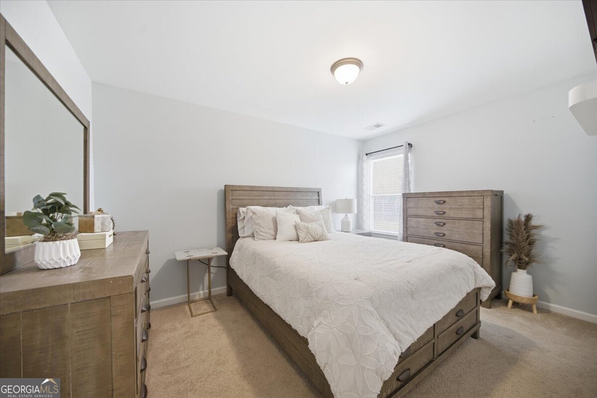 1201 Pendley Point Hampton, GA 30228 - Photo 19 of 23 a bedroom with a bed and a dresser
