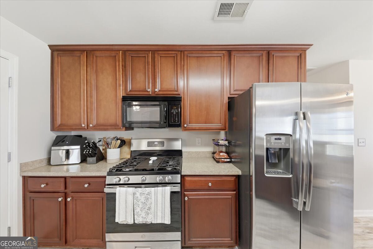 1201 Pendley Point Hampton, GA 30228 - Photo 6 of 23 a kitchen with stainless steel appliances granite countertop a refrigerator and a stove