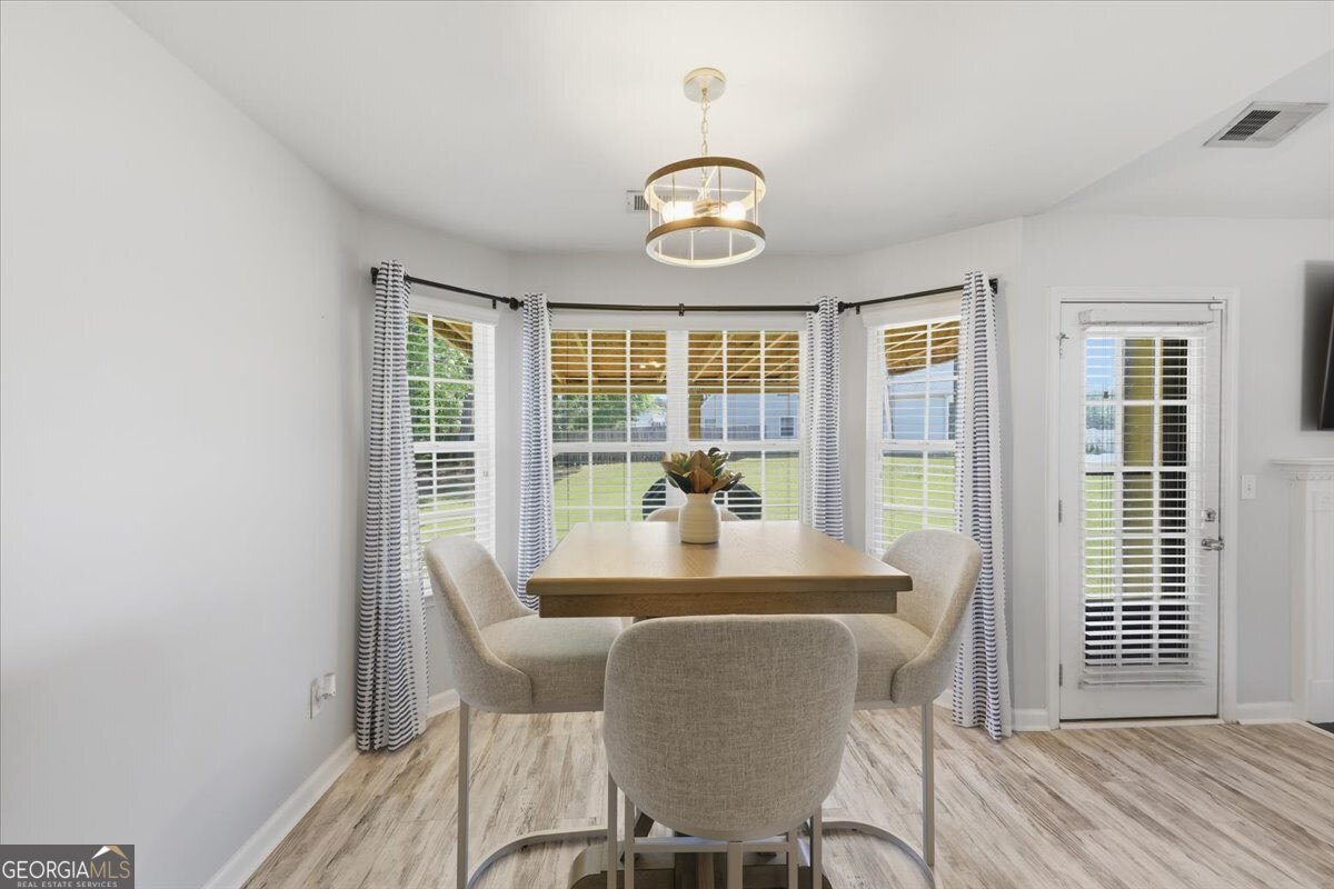 1201 Pendley Point Hampton, GA 30228 - Photo 9 of 23 a dining room with furniture wooden floor and a rug