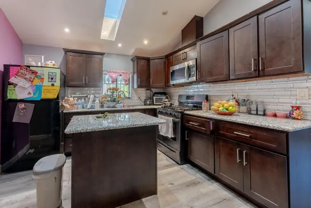 a kitchen with stainless steel appliances granite countertop a sink stove and cabinets