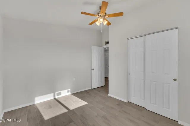 an empty room with a window and a fan