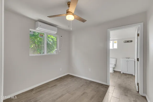 an empty room with windows and fan