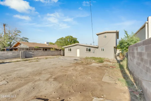 a view of a white house next to a yard with road