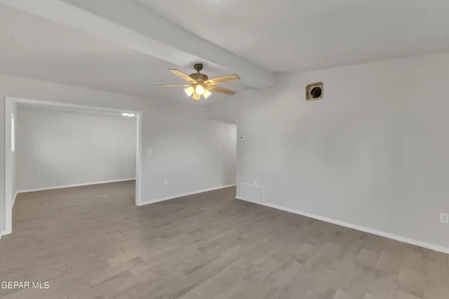 an empty room with window and wooden floor