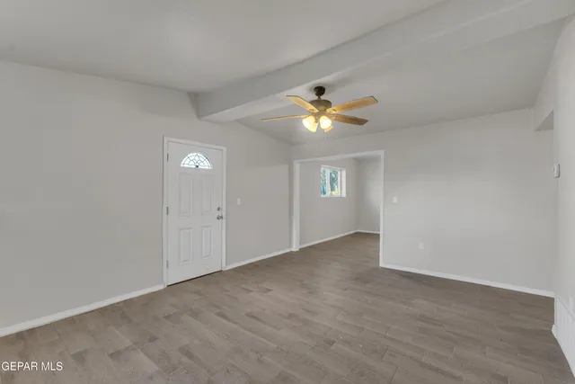 a view of a big room with wooden floor and windows