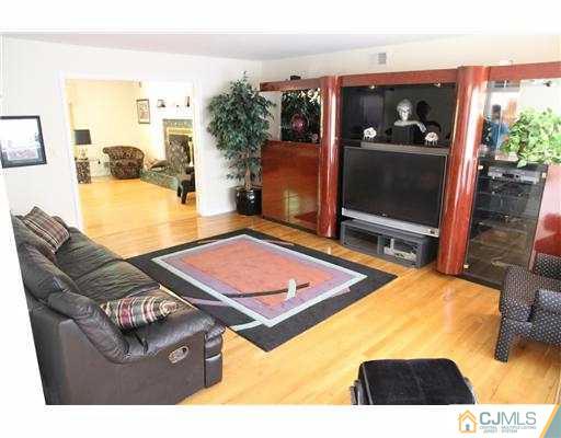 80 Ellmyer Road Edison, NJ 08820 - Photo 4 of 25 a living room with furniture a flat screen tv and a floor to ceiling window