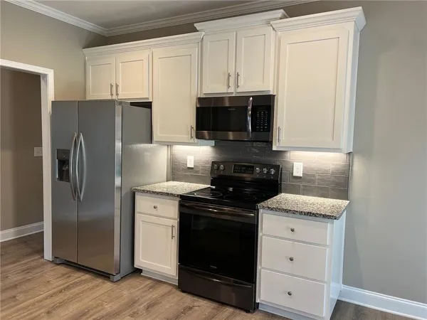a kitchen with stainless steel appliances granite countertop a refrigerator stove and sink