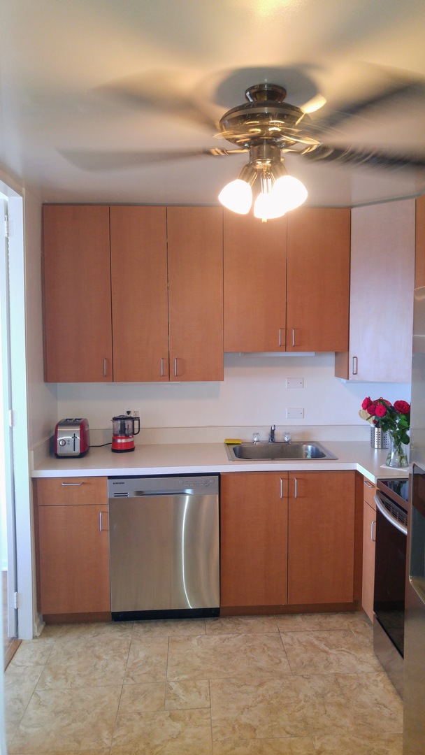 5445 North Sheridan Road, Unit 2504 Chicago, IL 60640 - Photo 11 of 37 a kitchen with granite countertop a sink and cabinets