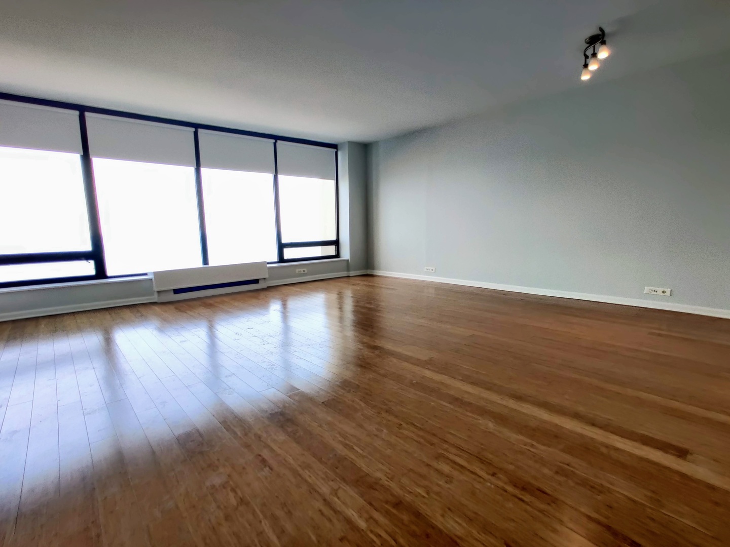 5445 North Sheridan Road, Unit 2504 Chicago, IL 60640 - Photo 13 of 37 a view of an empty room with wooden floor and a window