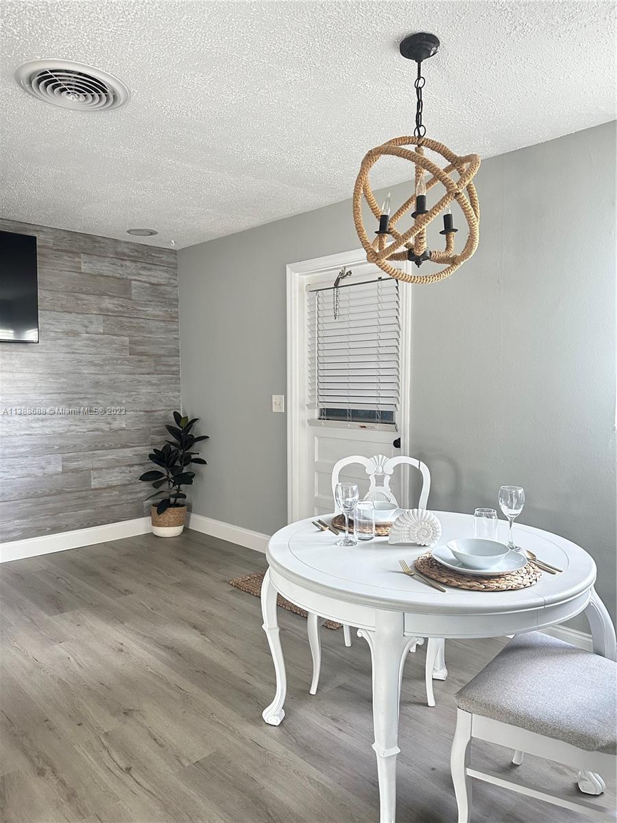 300 E Circle Jupiter, FL 33458 - Photo 11 of 28 a view of a dining room with furniture wooden floor and a chandelier