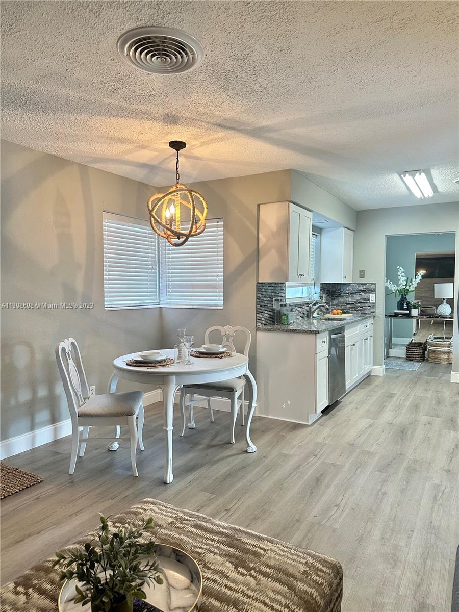 300 E Circle Jupiter, FL 33458 - Photo 13 of 28 a living room with furniture a rug and kitchen view