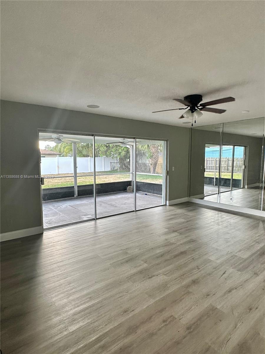 300 E Circle Jupiter, FL 33458 - Photo 15 of 28 an empty room with wooden floor and windows