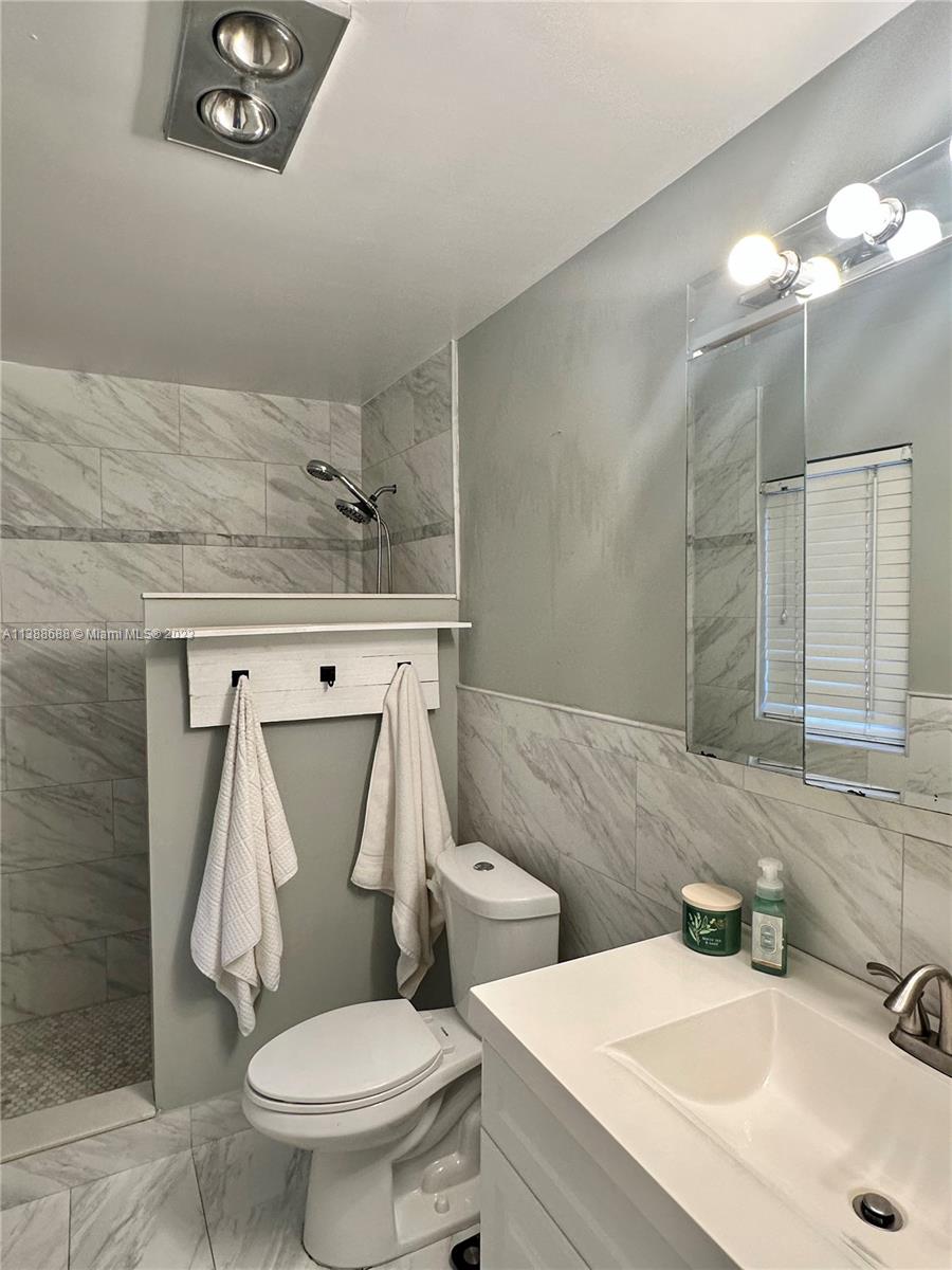 300 E Circle Jupiter, FL 33458 - Photo 17 of 28 a bathroom with a toilet sink and mirror