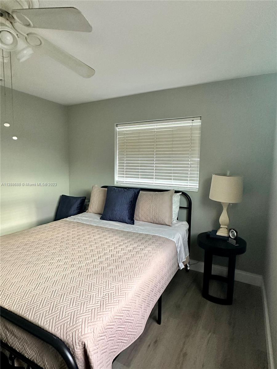 300 E Circle Jupiter, FL 33458 - Photo 20 of 28 a bedroom with bed and a night stand