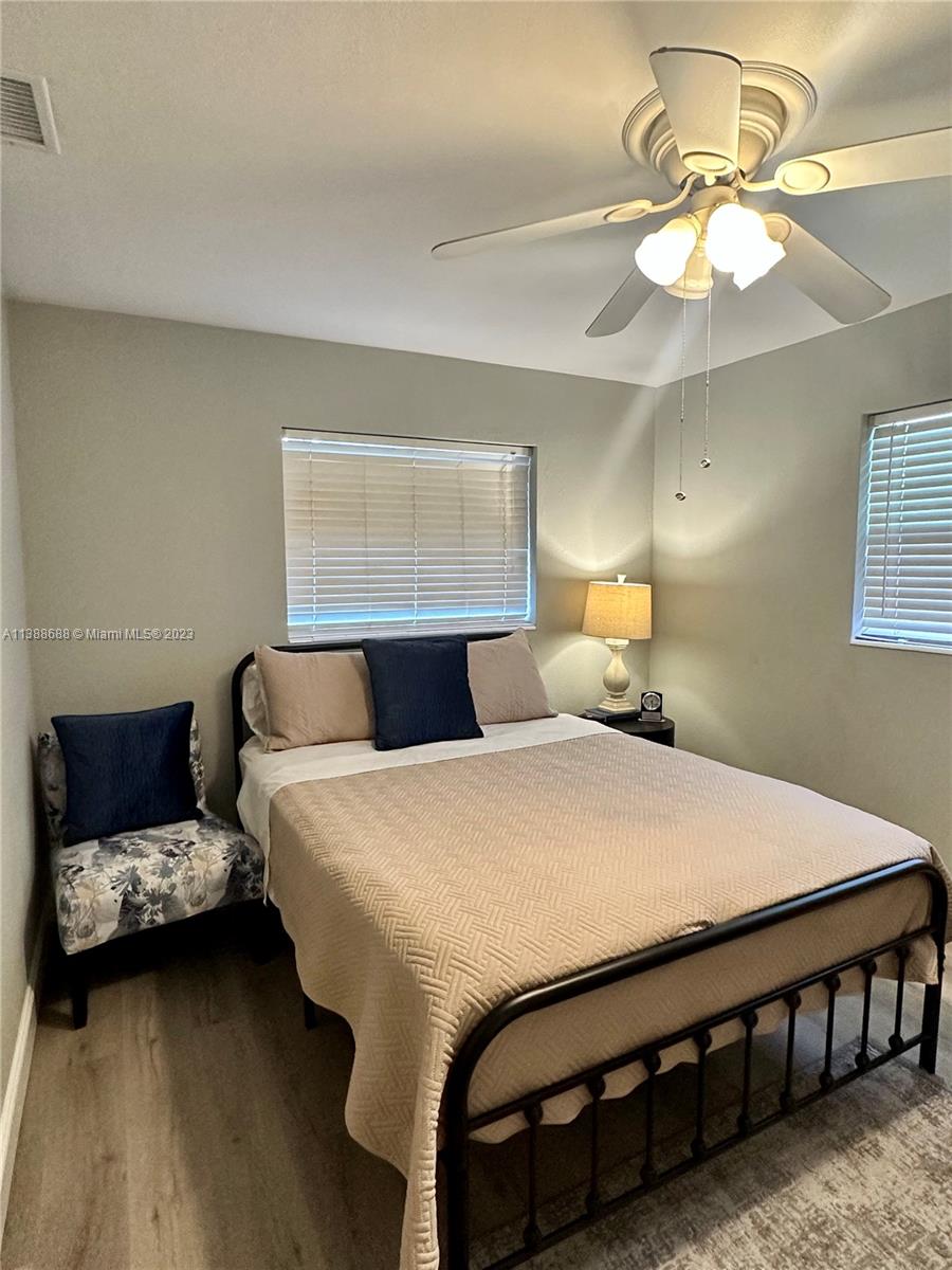 300 E Circle Jupiter, FL 33458 - Photo 21 of 28 a bedroom with a bed and a chandelier