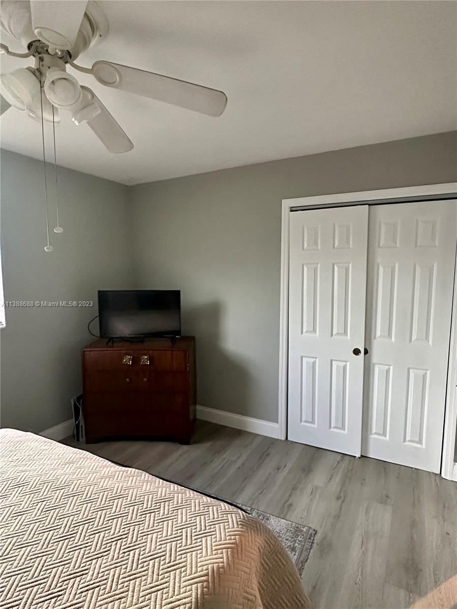 300 E Circle Jupiter, FL 33458 - Photo 25 of 28 a bedroom with a bed and a flat tv screen on dresser