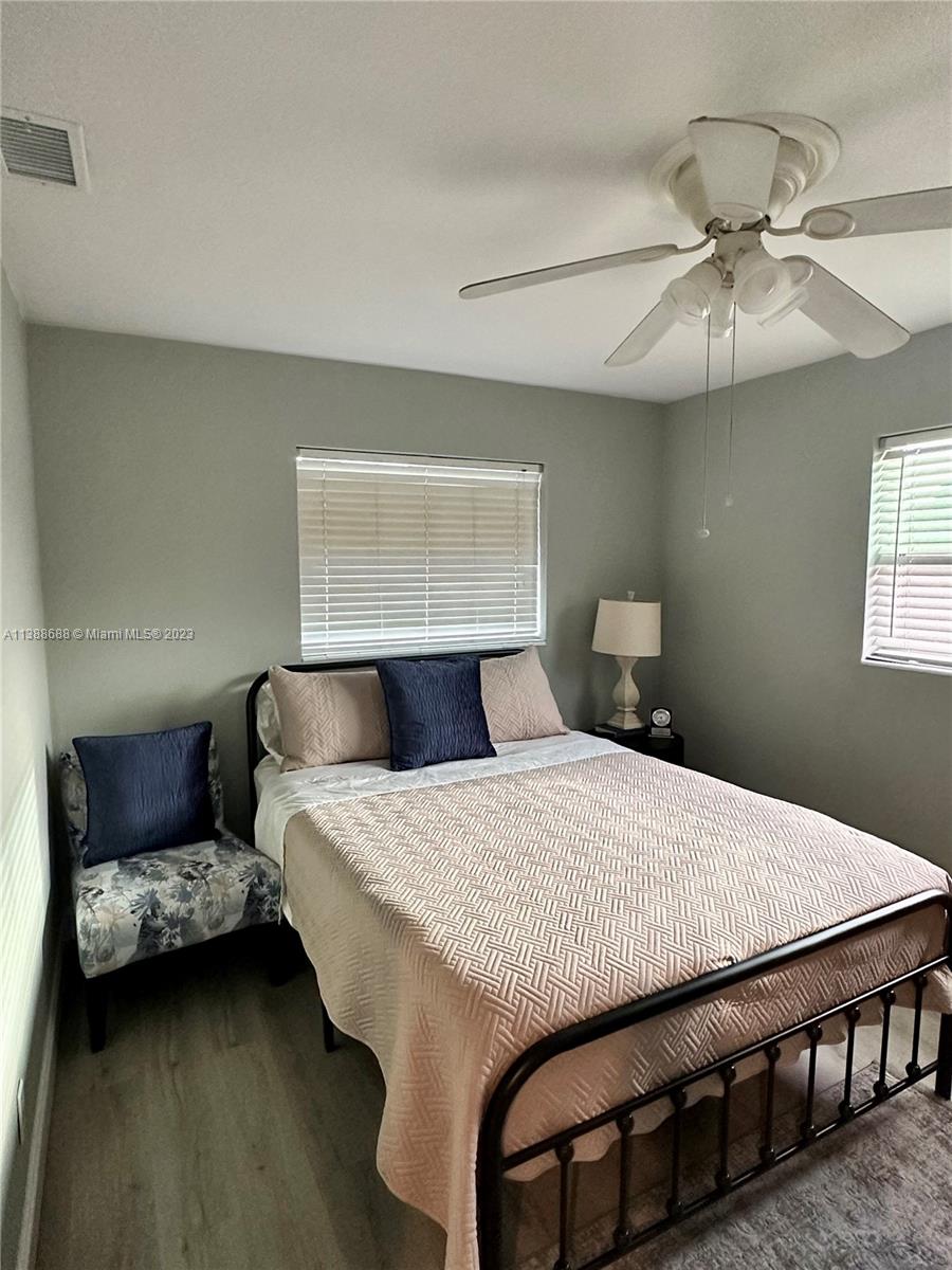 300 E Circle Jupiter, FL 33458 - Photo 27 of 28 a bedroom with a bed and a chandelier