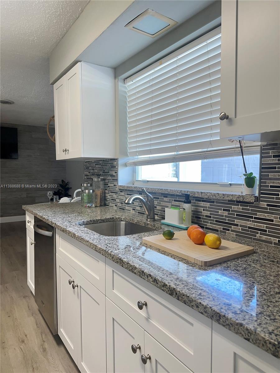 300 E Circle Jupiter, FL 33458 - Photo 6 of 28 a kitchen with sink and a wooden cabinets