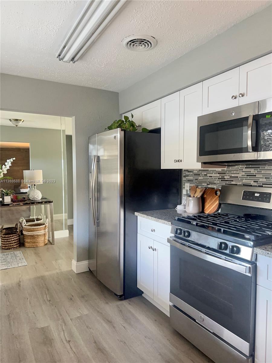 300 E Circle Jupiter, FL 33458 - Photo 8 of 28 a kitchen with stainless steel appliances a stove microwave and a refrigerator