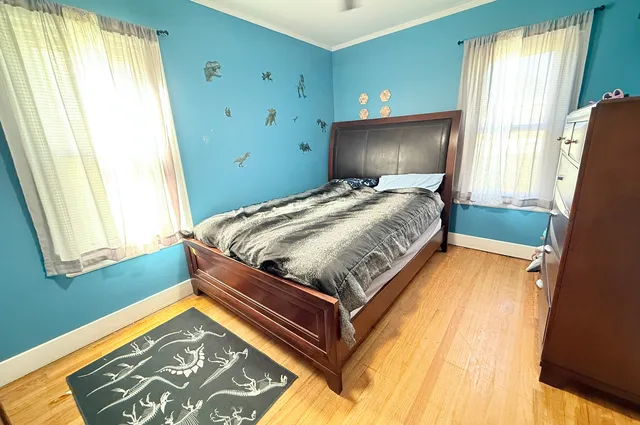 a bed sitting in a bedroom next to a window